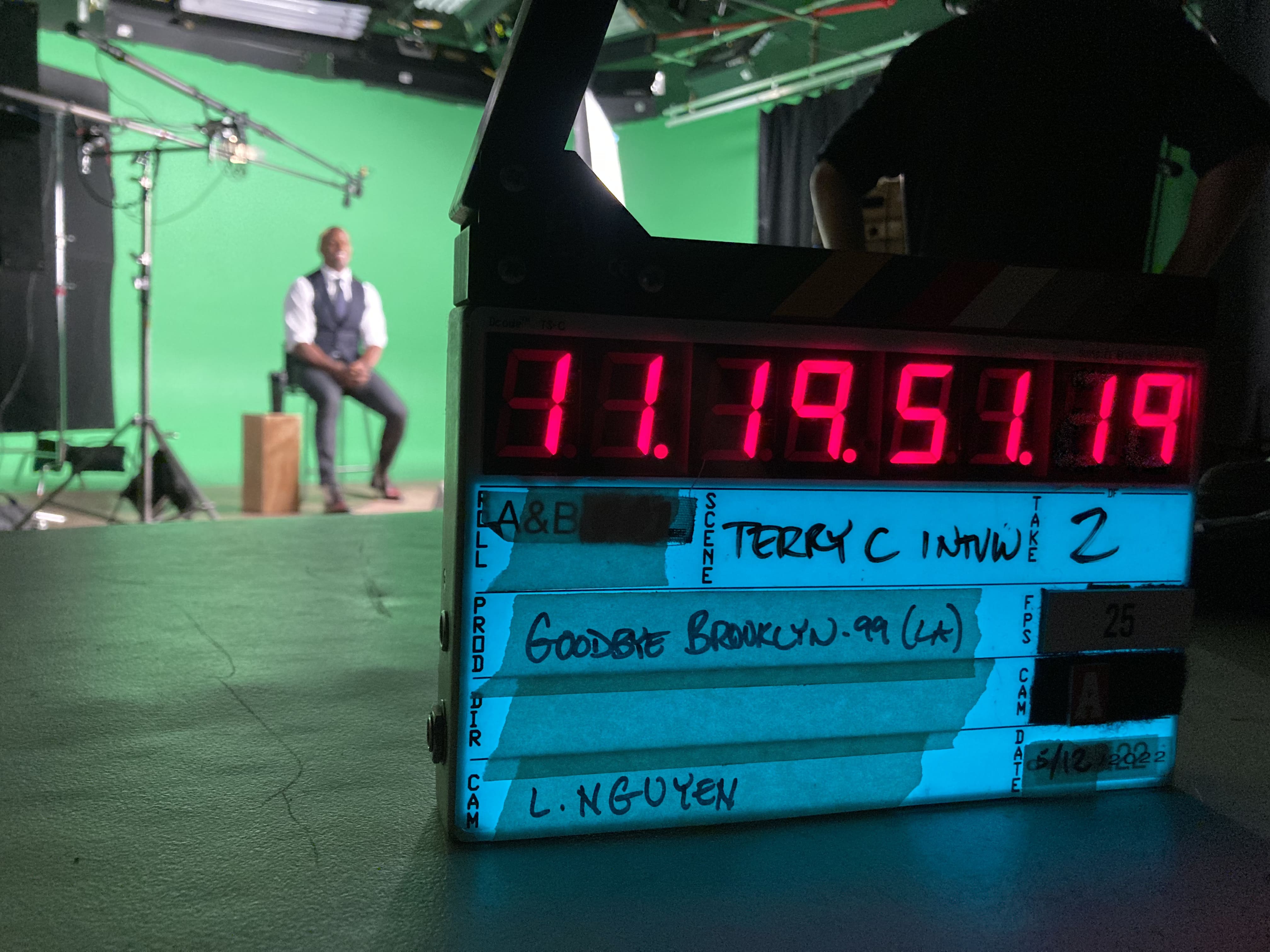Terry Crews (Lieutenant Terry Jeffords) sits in front of a green screen in the background. In the foreground is a clapperboard